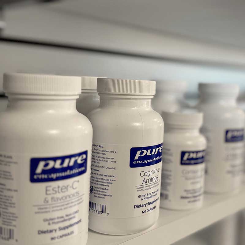 Pure Encapsulations supplements on shelves in white bottles